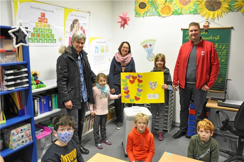 An der Worthschule ist die Luft rein: Vorsitzender Manuel Kossmann (li.) mit Tochter Maya und sein Vize Nils Lamm (re.) mit Tochter Wanda freuen sich zusammen mit Klassenlehrerin Tanja Torke (Mitte) darüber, dass die vom Schulverein gespendeten Automaten alle sechs Klassenräume sauber halten. Leonas Nitz, Klemens Ahlborn und Tim Bennet Kopp (vorn von links) schließen sich dem per Herzchen-Karte geäußerten Dankeschön gern an.  Foto: Heine