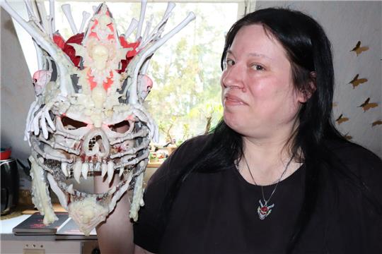 Frau hält Maske in der Hand. 