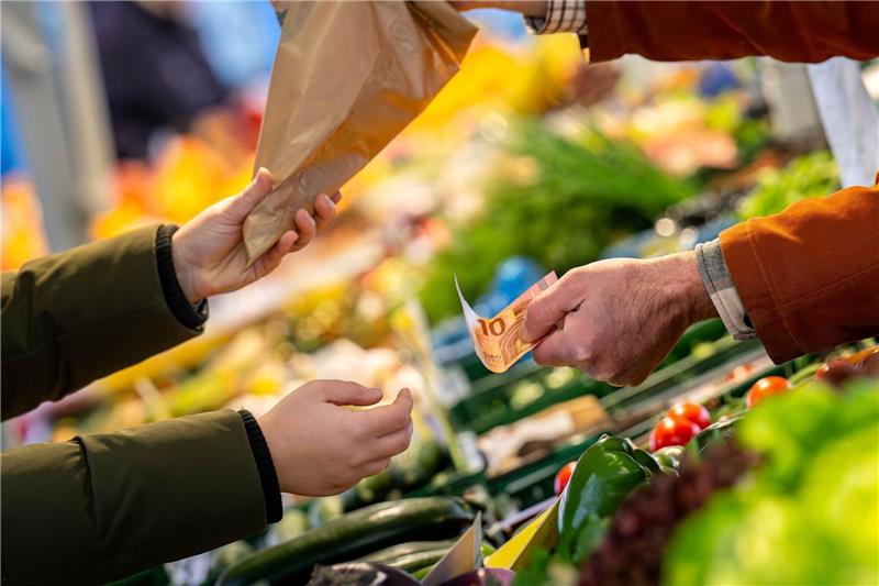 Niedrigste Inflationsrate seit Juni 2021 An einem Marktstand wird mit Bargeld eingekauft: Höhere Teuerungsraten schmälern die Kaufkraft von Verbrauchern.