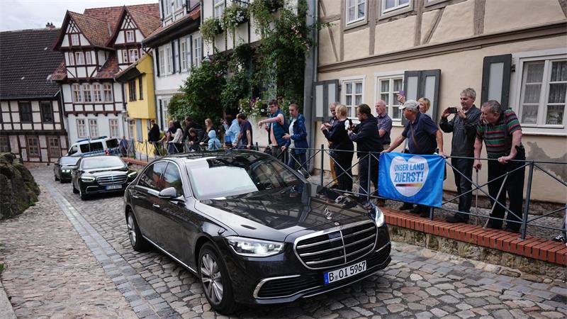 An einer Gruppe Demonstranten empfängt Merz in Quedlinburg.