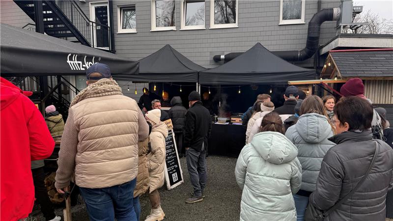 Besucher schlendern am Pagodenzelten entlang.