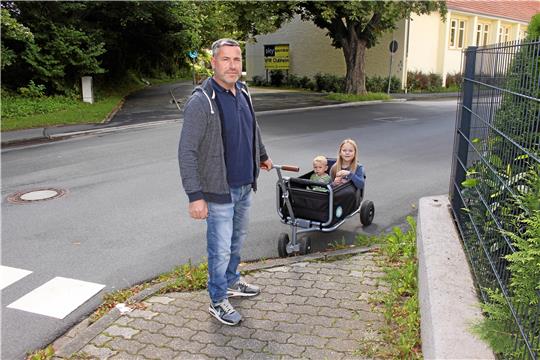 Andreas Fiolka kann den Bollerwagen mit seiner Tochter Odilia und seinem Sohn Eddie nur mit Mühe über die hohe Bordsteinkante ziehen. Foto: Wendt