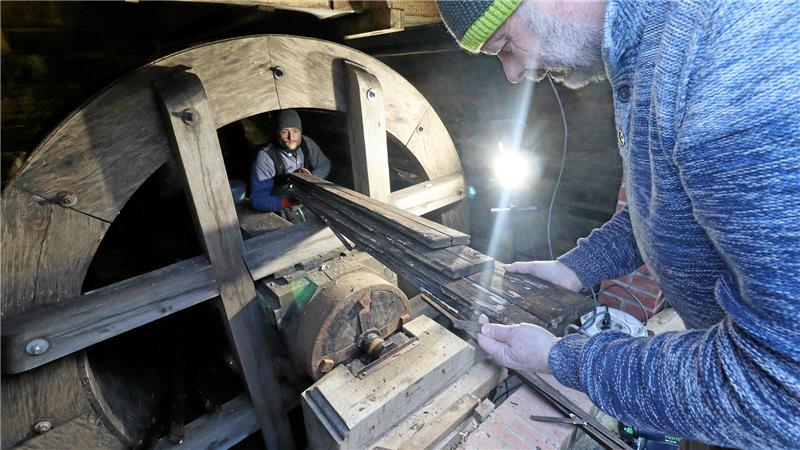 Andreas Weihe nimmt die verfaulten Bretter aus der Radstube entgegen.