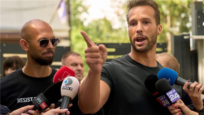 Anklage gegen Tate-Brüder wegen Vergewaltigung Andrew Tate (links) schaut zu seinem Bruder Tristan Tate, der am 21. Mai vor einer Polizeistation in Voluntari in Rumänien redete.