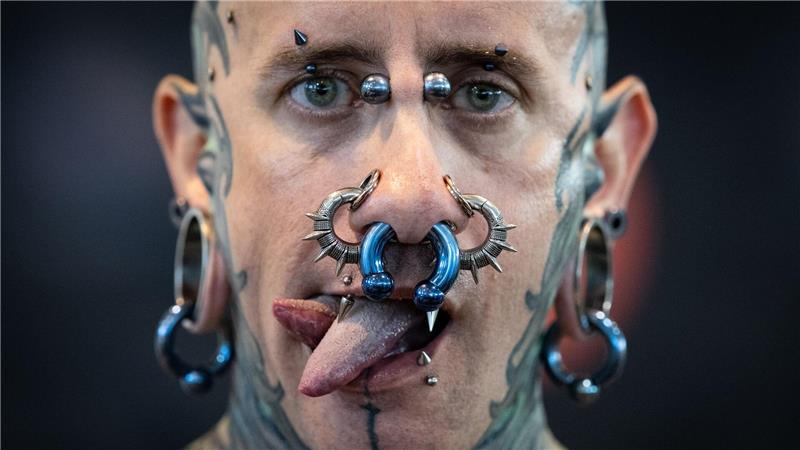 Andrew aus Spanien präsentiert Tattoos, Piercing und eine gespaltene Zunge auf der Tattoo Convention in Frankfurt.