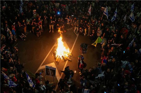 Angehörige und Unterstützer der israelischen Geiseln, die im Gazastreifen von der Hamas festgehalten werden, blockieren in Tel Aviv eine Straße und fordern ihre Freilassung.