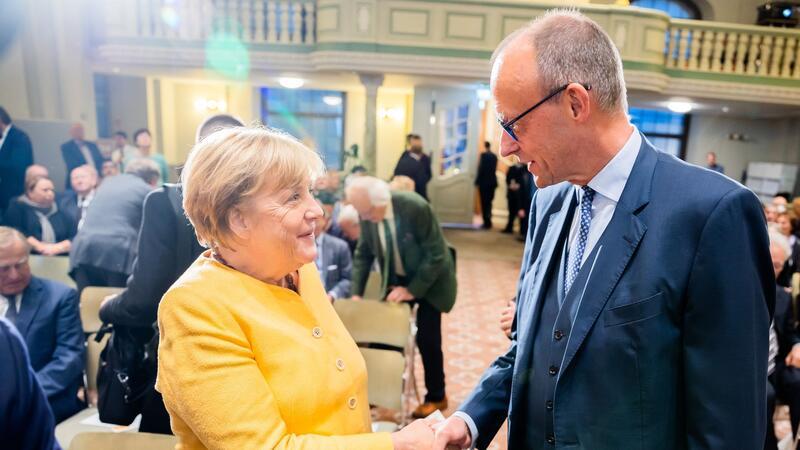 Angela Merkel und Friedrich Merz begrüßen sich bei der Eröffnungsveranstaltung der Bundeskanzler-Helmut-Kohl-Stiftung  im September 2022.