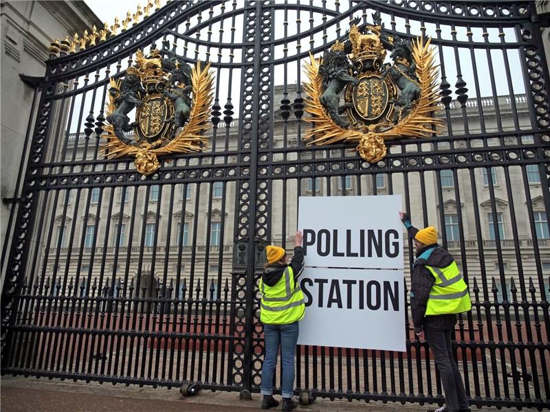 Teure Krönung von König Charles in der Kritik Anhänger der Kampagnengruppe Republic hängen ein Wahllokalschild ans Geländer des Buckingham Palace in London.