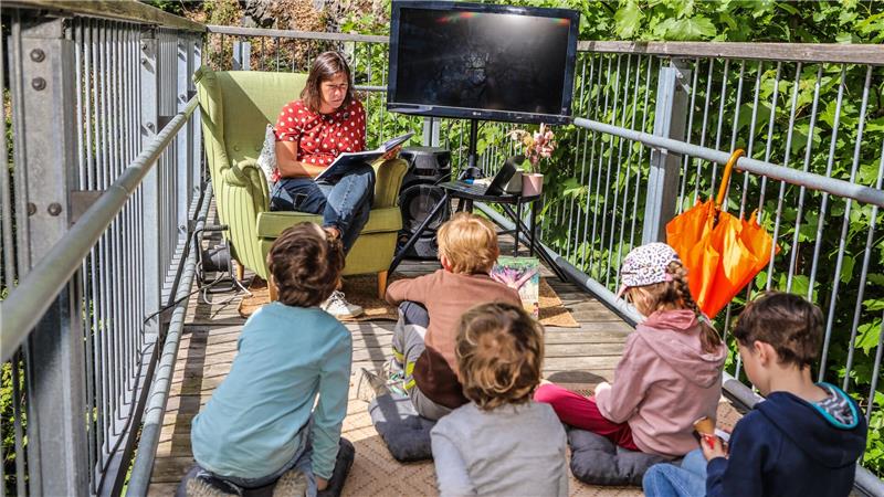 Anke Pahlenberg liest den Kindern auf der kleinen Plattform eine märchenhafte Geschichte vor.