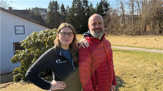 Das Foto zeigt eine Frau und einen Mann vor einem Haus.