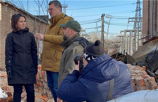 Annalena Baerbock im Gespräch mit dem ukrainischen Außenminister Dmytro Kuleba (3.v.r) in Charkiw auf dem Gelände eines den Russen zerstörten Umspannwerkes.