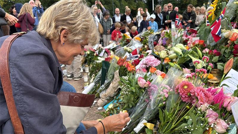 Anne Sandø Seierstad zündet eine Kerze für den gestorbenen Monarchen an. 