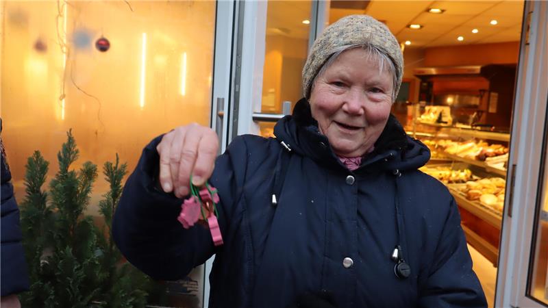 Frau hält Glücksbringer hoch.