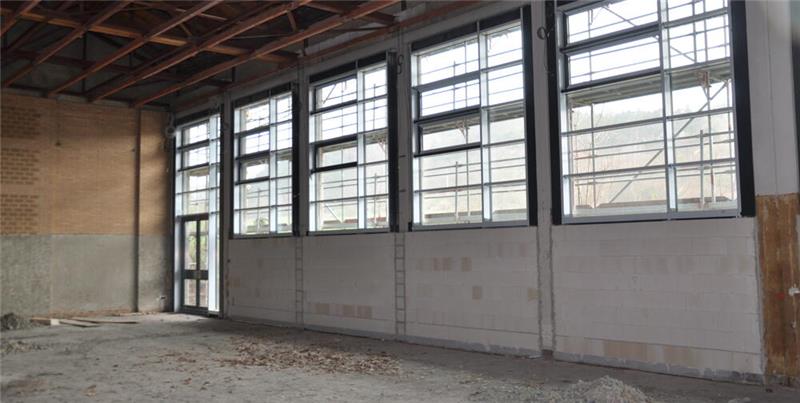 Oker drückt aufs Tempo: Millionenschwere Module rücken an Große Industriehalle mit hohen Fenstern, Betonboden und sichtbarer Holzbalkendecke