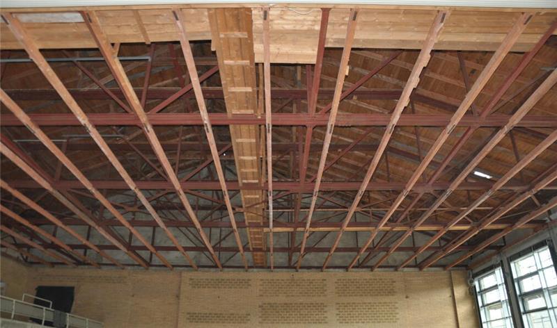 Oker drückt aufs Tempo: Millionenschwere Module rücken an Decke mit sichtbaren Holzbalken und Dachkonstruktion in einem Raum mit großen Fenstern