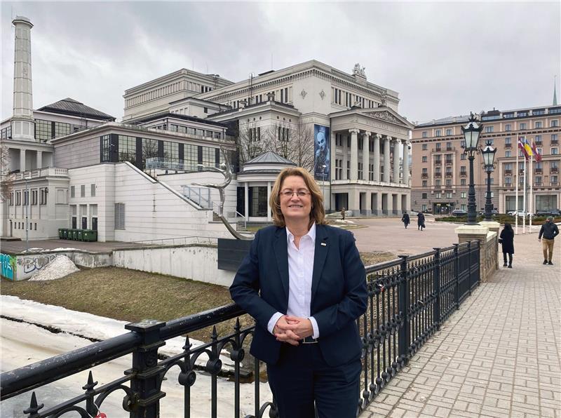Antje Grotheer steht während ihres Besuchs in Riga auf einer Brücke vor der lettischen Nationaloper.