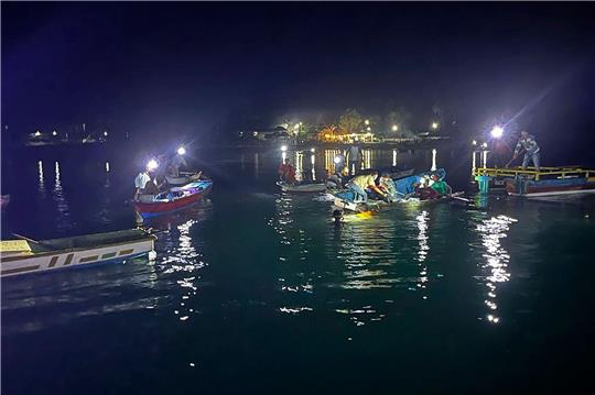 Anwohner und Mitarbeiter der Nationalen Such- und Rettungsbehörde suchen nach Überlebenden, nachdem eine Fähre vor der indonesischen Insel Sulawesi gekentert ist.