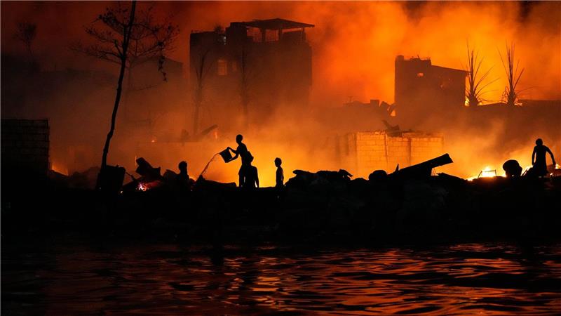 Anwohner versuchen mit Wassereimern ein Feuer zu bekämpfen, das in einer Armensiedlung in Manila ausgebrochen ist.