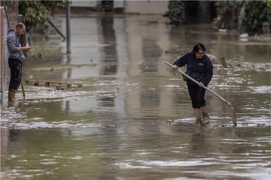 Anwohner versuchen nach Überschwemmungen eine Straße in Faenza von Schlamm und Wasser zu befreien.