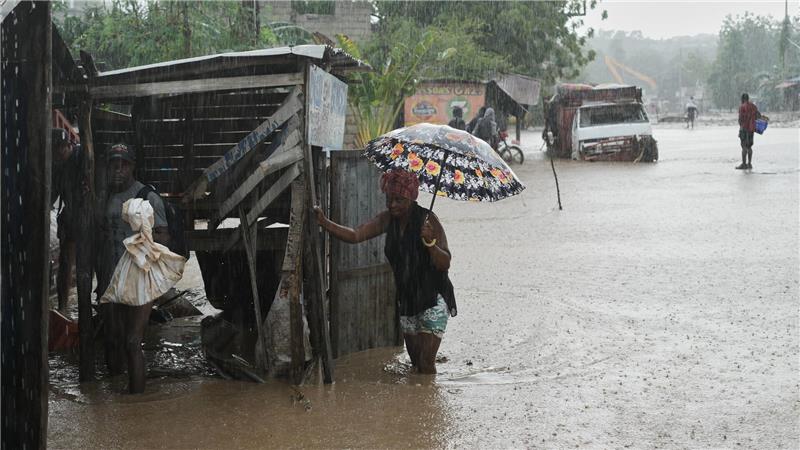 Anwohner waten durch eine überflutete Straße nach dem durchzug von Hurrikan Melissa in Petit-Goave.