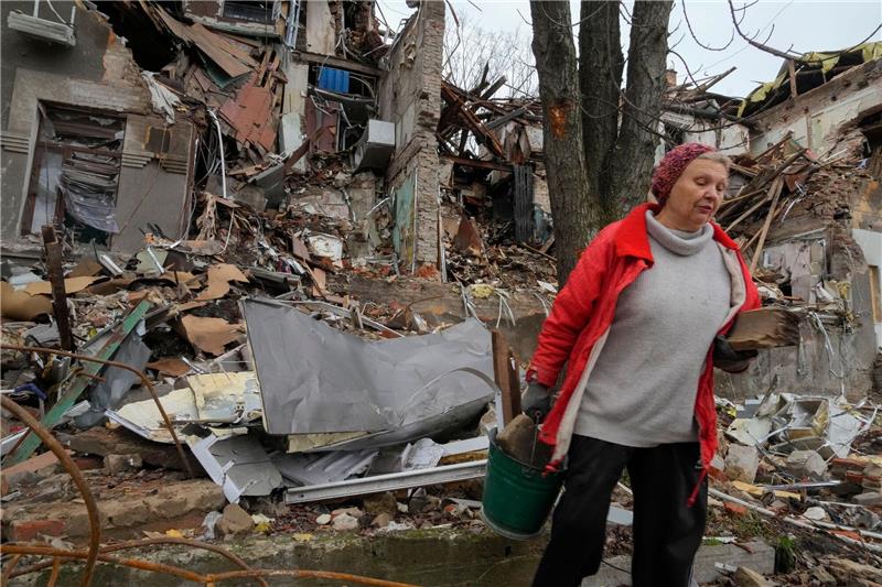 Krieg gegen die Ukraine: So ist die Lage Anwohnerin Nina (72) trägt in Slowjansk hölzerne Trümmer in der Nähe ihres Hauses, das durch Beschuss vor einem Monat zerstört wurde.