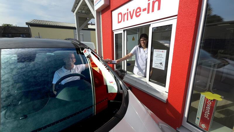 Apotheker Andreas Oppermann (im Auto) demonstriert mit Filialleiterin Annika Schulze, wie der Drive-In der Apotheke an der Wachtelpforte optimiert wurde.