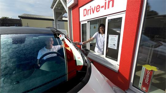 Apotheker Andreas Oppermann (im Auto) demonstriert mit Filialleiterin Annika Schulze, wie der Drive-In der Apotheke an der Wachtelpforte optimiert wurde.