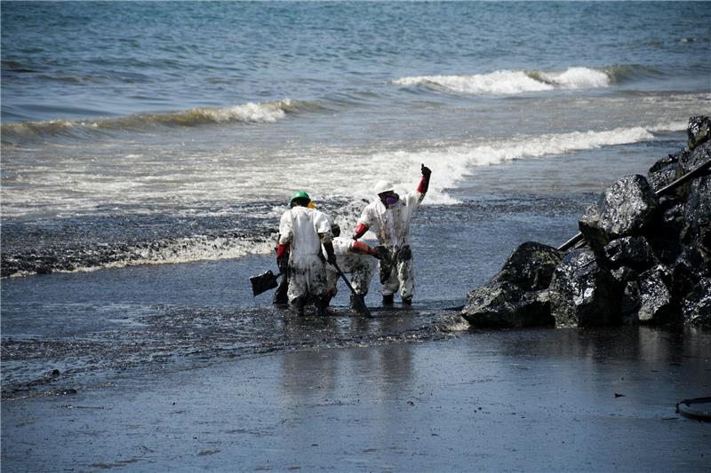 Karibik: Kilometerlanger Ölteppich vor Tobago bedroht Natur Arbeiter beseitigen einen Ölteppich, der den Strand von Rockly Bay in Scarborough im Südwesten Tobagos erreicht hat.