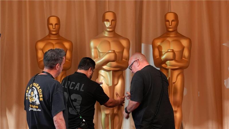 Arbeiter bewegen Oscar-Statuen entlang des roten Teppichs vor der Oscar-Verleihung in Los Angeles.