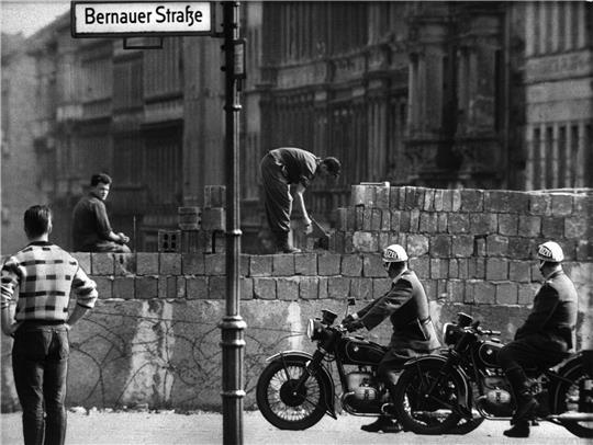 Arbeiter erhöhen die Sektorensperre an der Bernauer Straße in Berlin. Mit dem Bau am 13. August wurde vor 62 Jahren begonnen.