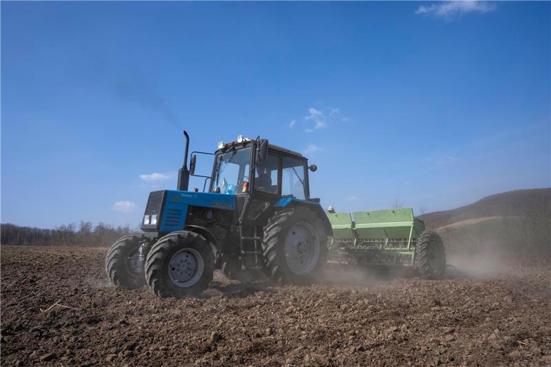 Ukraine will Landwirtschaft für EU modernisieren Arbeiter pflügen ein Weizenfeld im Westen der Ukraine.