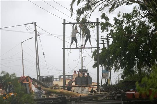 Arbeiter reparieren in Indien einen Transformator, um die Stromversorgung wiederherzustellen.