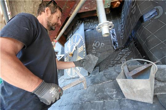 Arbeitsplatz Kirchturmuhr: In den kommenden Wochen sind die Dachdecker damit beschäftigt, Tausende neue Schieferplatten am Turmdach zu befestigen. Foto: Gereke