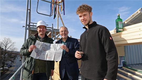 Architekt Christian Spahn (l.) zeigt gemeinsam mit dem JKCS-Vorsitzenden Wolfgang Kummer die erste Ideenskizze vom 29. Dezember 2021. Für den Zimmermann-Auszubildenden Arian Wückener ist es der erste Richtspruch.