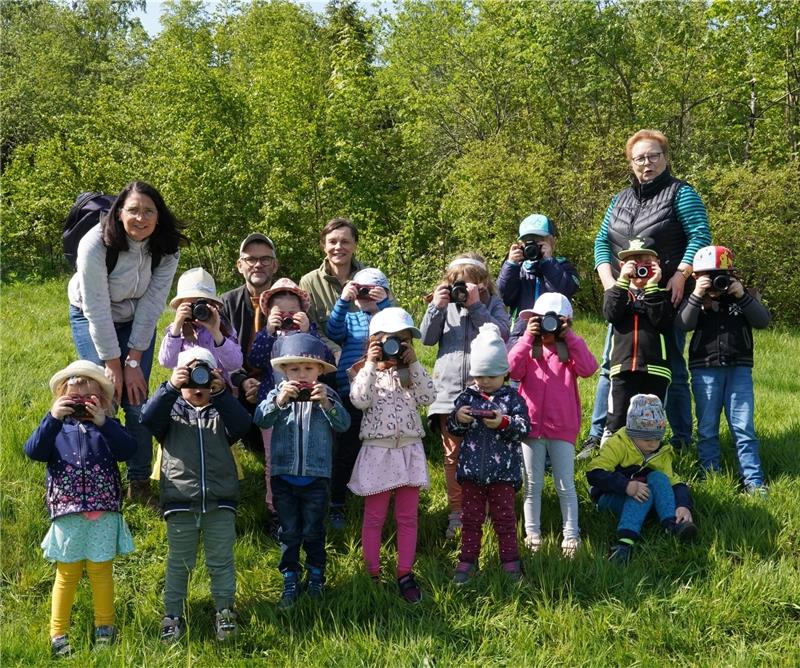 Arne Bunk und Tanja Bächlein (2. und 3. v.l.) vom Verein „bild + begegnung“ haben für jedes Kind eine Kamera mitgebracht. Gemeinsam erkunden sie den Kurpark, den Märchenwald und Bergwiesen. Foto: Bode