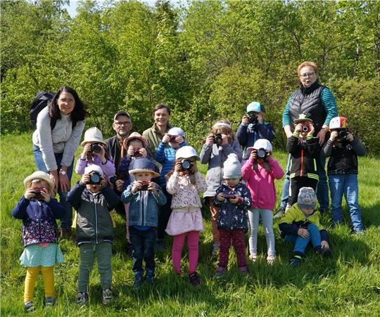 Arne Bunk und Tanja Bächlein (2. und 3. v.l.) vom Verein „bild + begegnung“ haben für jedes Kind eine Kamera mitgebracht. Gemeinsam erkunden sie den Kurpark, den Märchenwald und Bergwiesen. Foto: Bode