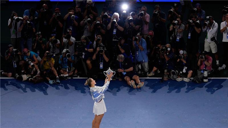 Aryna Sabalenka präsentiert den Fotografen ihren Pokal.