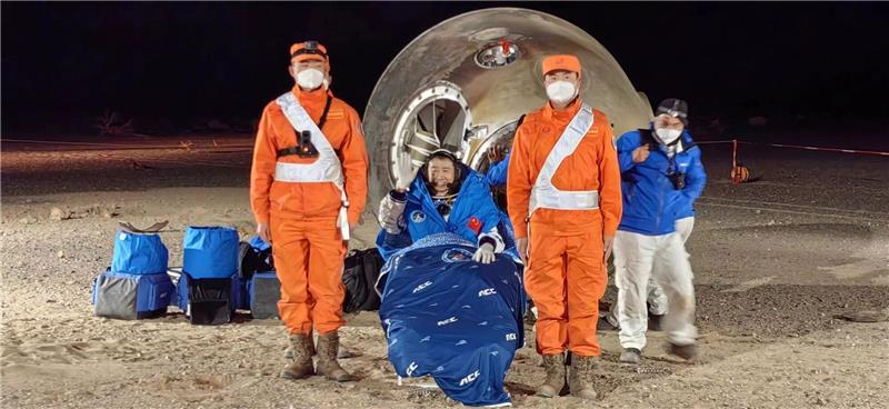 Chinesische Astronauten nach sechs Monaten zurück auf Erde Astronaut Chen Dong winkt, nachdem er aus der Rückkehrkapsel geborgen wurde.