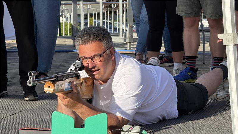 Das Bild zeigt Braunlages Bürgermeister Wolfgang Langer, wie er liegend mit einem Gewehr zielt. 