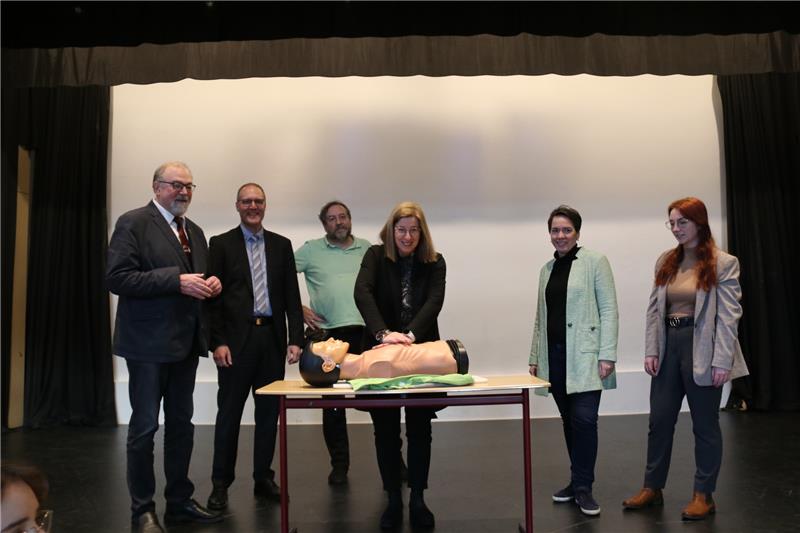 Goslarer Schüler sollen zu Lebensrettern werden Auch Pressesprecherin Dagmar Kleudgen versucht sich an der Wiederbelebung. Schulleiter Hans-Peter Dreß, Volksbank Nordharz Vorstand Markus Creydt, Lehrer Stefan Bolde-Müller, Schatzmeisterin des Elternvereins Tanja Peterson und Auszubildende Lea Sefrin (v.r.) beobachten das Ganze aus der hinteren Reihe. Foto: Fricke