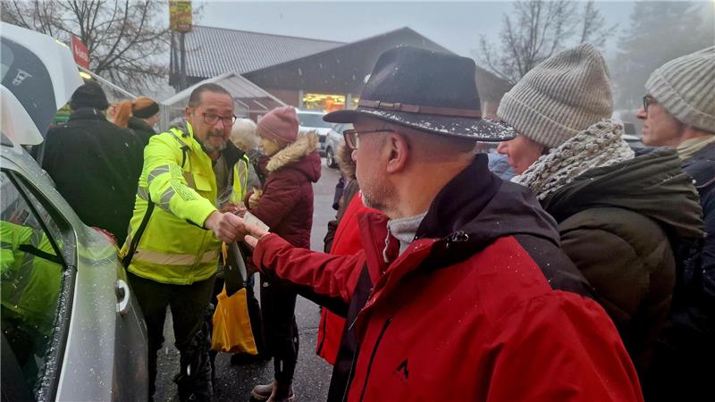 Ein Mann überreicht einem anderen zwei Geldscheine.