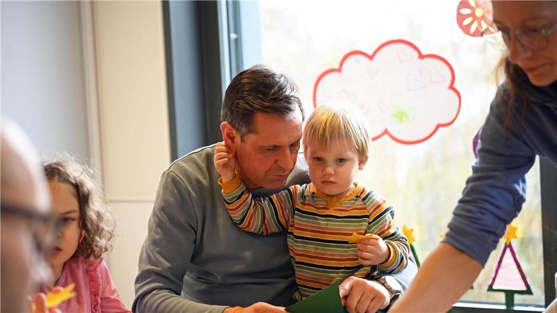 Ministerpräsident bastelt mit Glitzer in Kita Auch das gehört zum Arbeitsalltag in der Kita ‒ ein Kind greift nach dem Ohr des Ministerpräsidenten.