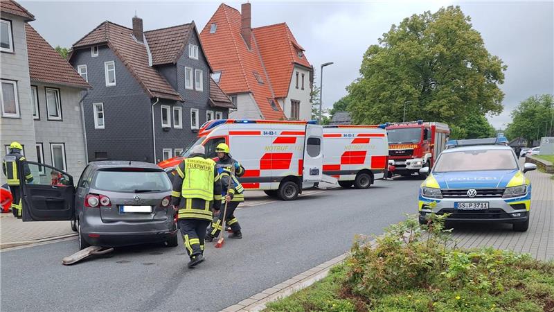 Das Bild zeigt ein demoliertes Auto, drumherum Feuerwehrleute sowie im Hintergrund Rettungswagen und ein Polizeifahrzeug. 