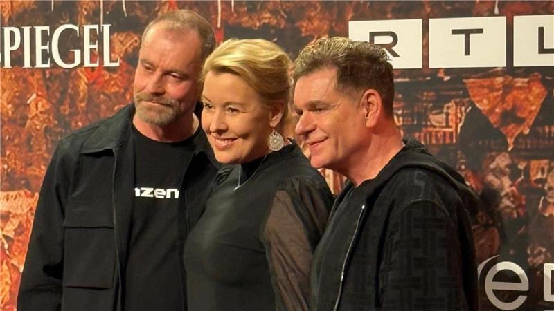 Drei Personen stehen nebeneinander vor einer Wand mit den Logos von SPIEGEL und RTL