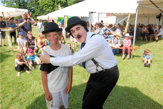 Auch ein Charlie-Chaplin-Darsteller ist bei den Feierlichkeiten der Fröhlichen Bodensteiner auf dem Bolzplatz des Dorfes zu Gast und erfreut das Publikum.  Fotos: Gereke