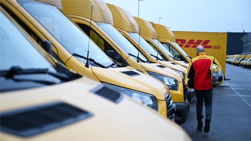 Elektro-Anteil in der Paketbranche steigt Auch er fährt Stromer: ein DHL-Paketbote auf dem Weg zu seinem Elektro-Transporter.