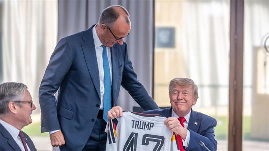 Auch für die Trikotübergabe an Trump musste Merz Kritik einstecken.