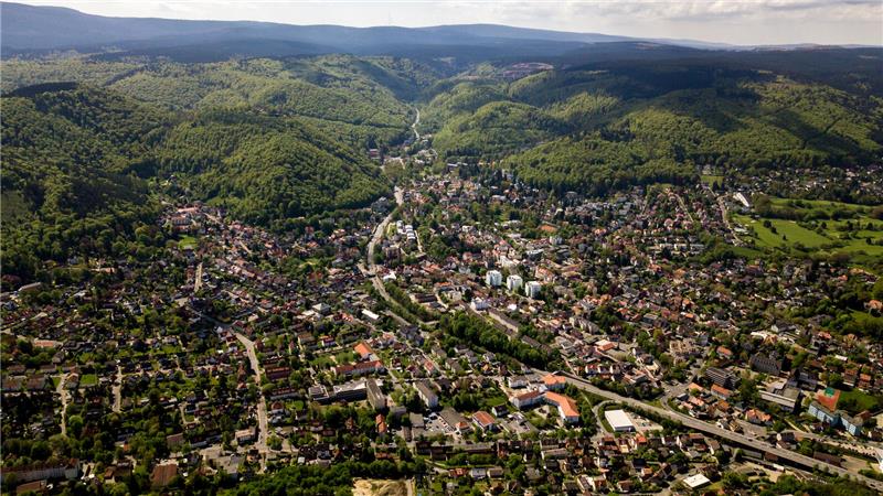 Das Bild zeigt eine Luftaufnahme von Bad Harzburg mit Bergen im Hintergrund. 
