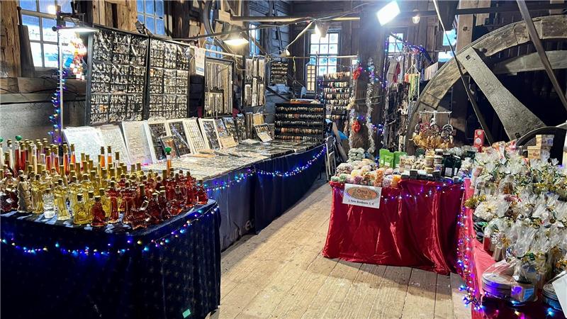 In einem Raum stehen weihnachtlich geschmückte Tische mit eingepackter Ware drauf.