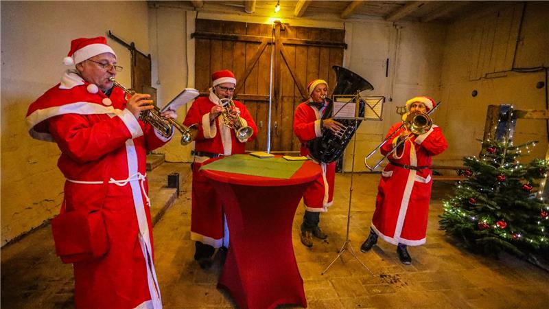 Bad Harzburg: So gewaltig ist der diesjährige Adventsmarkt im Gestüt Vier Menschen musizieren gemeinsam und sind dabei mit Weihnachtsmannkostümen verkleidet.